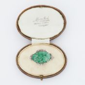 An 18ct white gold brooch set with oval carved piece of jade with leaf design, measuring approx. 2.