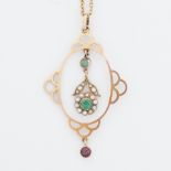 An antique yellow gold pendant set with seed pearls, two round cut emeralds and a round cut