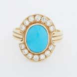 An 18ct yellow gold cluster style ring set with a central oval cabochon cut turquoise, measuring