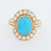 An 18ct yellow gold cluster style ring set with a central oval cabochon cut turquoise, measuring