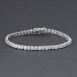 A 9ct white gold line bracelet (stamped 9k) set with round brilliant cut crystals, push in clasp &