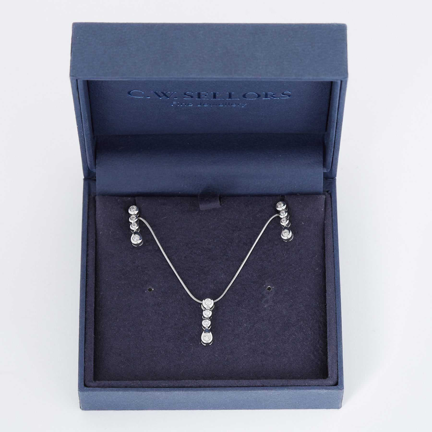 An 18ct white gold pendant & matching earrings each set with four small round brilliant cut