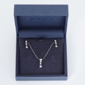 An 18ct white gold pendant & matching earrings each set with four small round brilliant cut