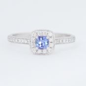 An 18ct white gold ring set with a central square cut tanzanite, approx. 0.39 carats, surrounded