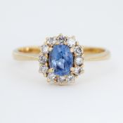 An 18ct yellow gold cluster ring set with a central oval cut sapphire, approx. 0.83 carats