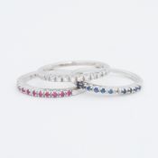 A set of three 14ct white gold stacking rings, one set with sapphires, one with rubies and one