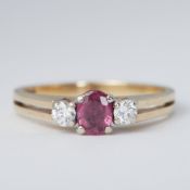 A 9ct yellow & white gold three stone ring set with a central oval cut ruby, approx. 0.20 carats,