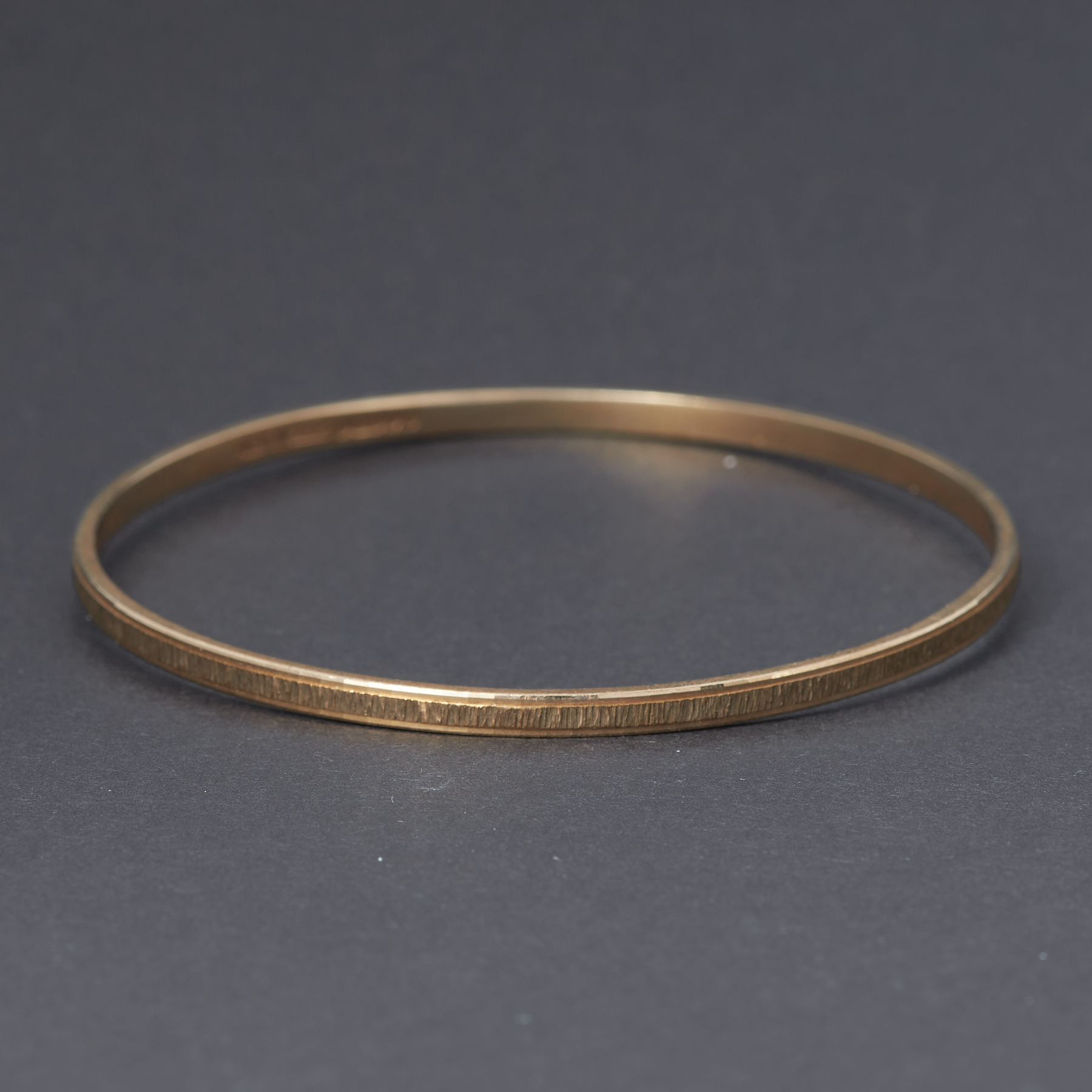 A 9ct yellow gold textured design bangle, inner diameter approx. 6.3cm, 11.32gm.