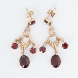 A pair of ornate 9ct yellow gold drop earrings set with oval & round cut garnets, measuring