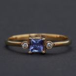 An 18ct yellow gold ring set with a princess cut tanzanite, approx.0.30 carats with a round