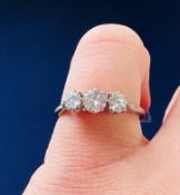 A platinum three stone ring set with old round brilliant cut diamonds, total diamond weight
