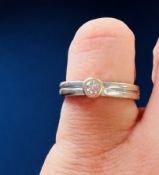 An 18ct white gold ring set with a round brilliant cut diamond, approx. 0.10 carats, in a rubover