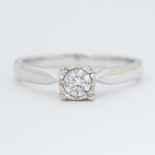 An 18ct white gold ring set with 0.34 carats of round brilliant cut diamond in an illusion