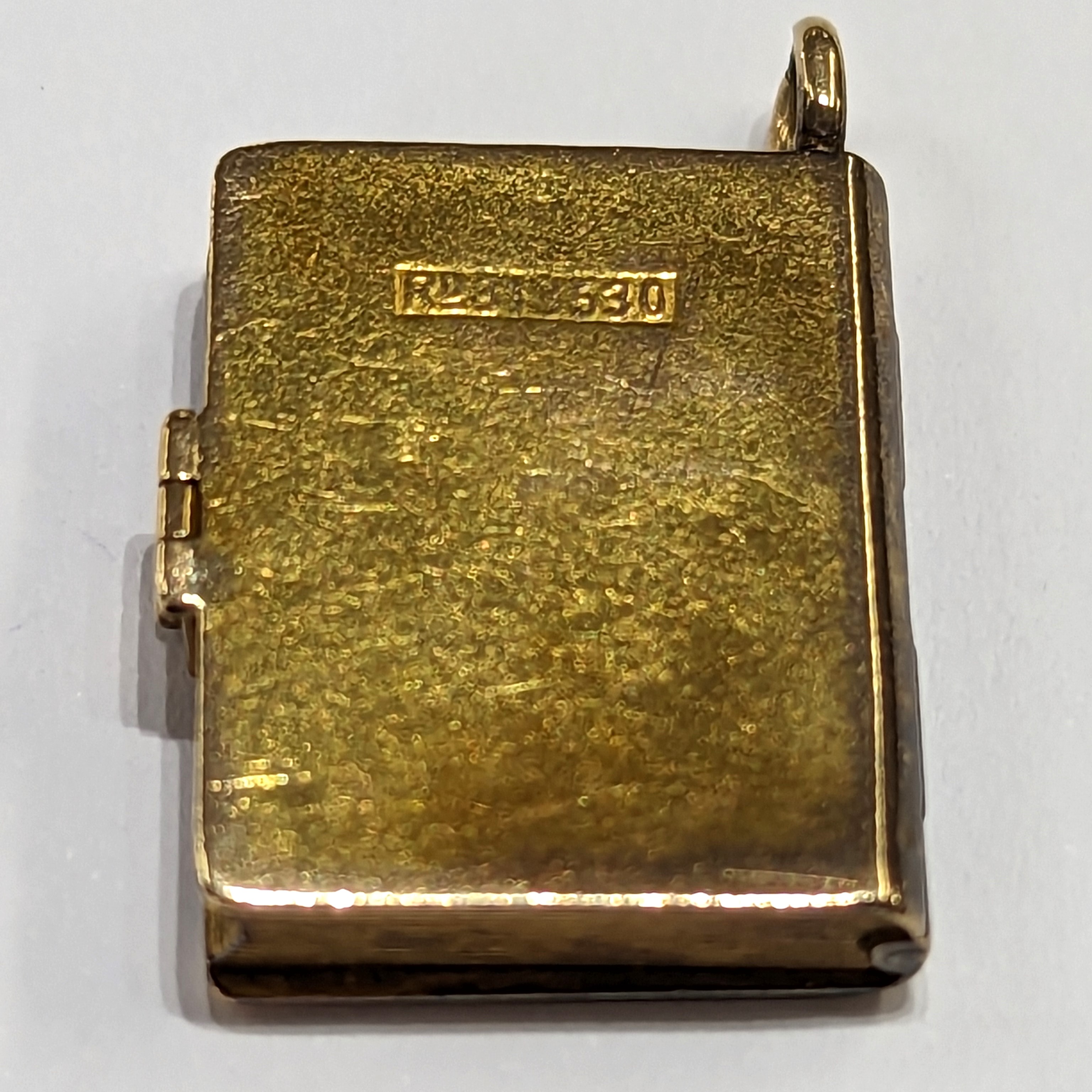 A gold locket in the shape of a book inset with a Dove & envelope set with a small ruby, measuring - Image 3 of 5