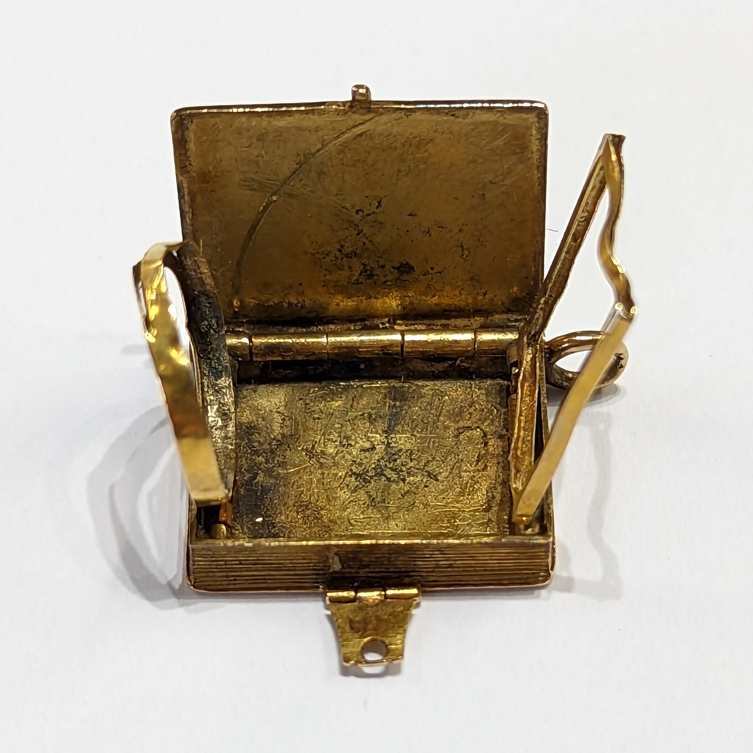A gold locket in the shape of a book inset with a Dove & envelope set with a small ruby, measuring - Image 5 of 5