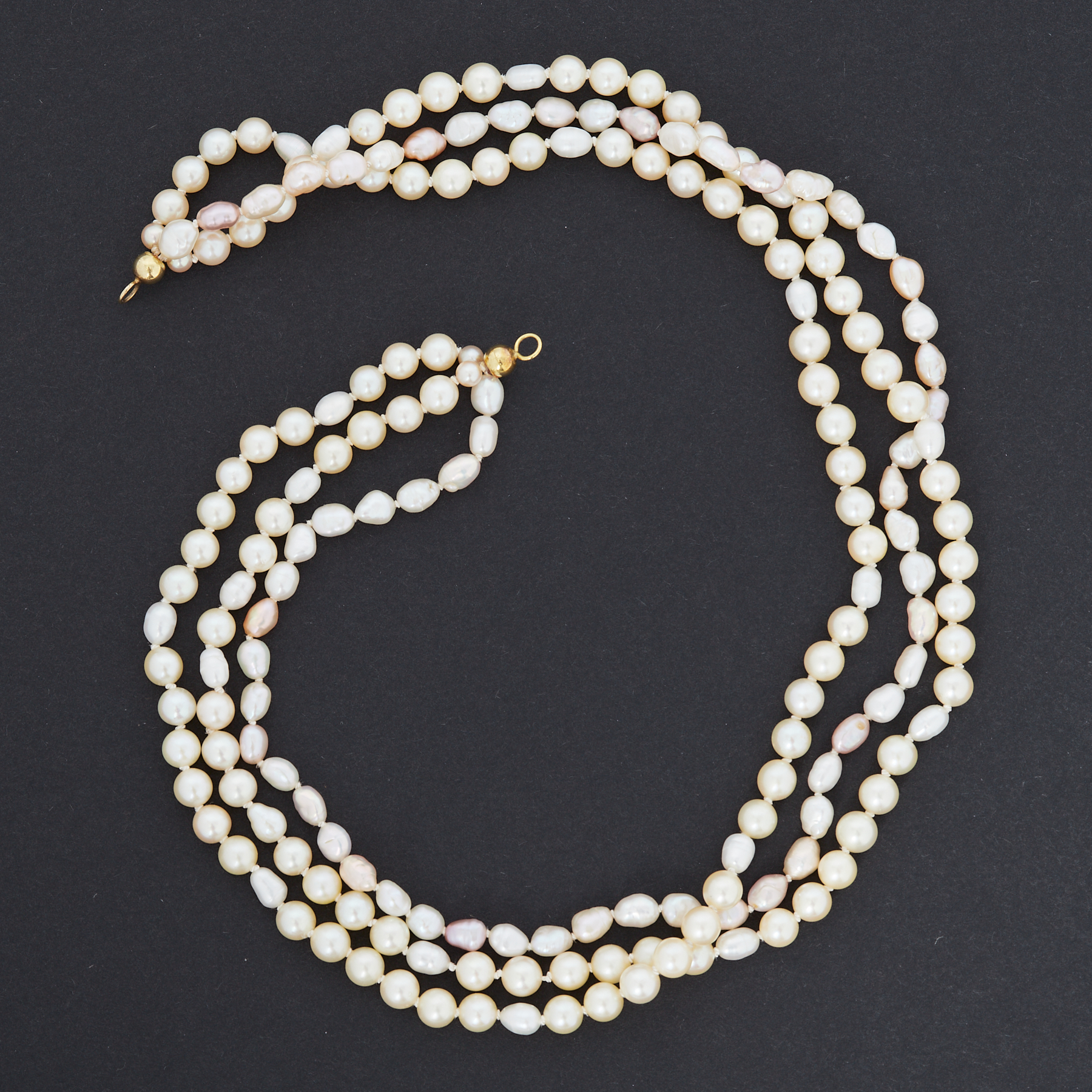 A triple row of pearls of varying shapes and colours from cream to pink, approx. 16", round pearls