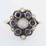 An Arts & Crafts yellow gold & white metal ring set with small round cut sapphires & pearls, the