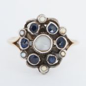 An Arts & Crafts yellow gold & white metal ring set with small round cut sapphires & pearls, the