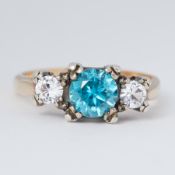 A yellow & white gold ring set with a central round cut blue zircon, approx. 0.66 carats, set each