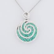 An 18ct white gold swirl design pendant set with round cut emeralds and round brilliant cut