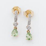 A pair of 9ct yellow & white gold drop earrings set with a pear shaped peridot and small round cut
