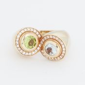 An unusual 14ct yellow gold ring set with a round cut peridot and a round cut aquamarine, both