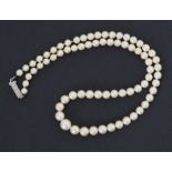 An 18" string of graduated cultured pearls set to a rectangular platinum? clasp set with four