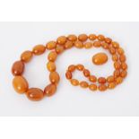 A 24" string of oval butterscotch amber beads and one loose oval butterscotch amber bead, total