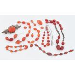 A collection of Carnelian? Jewellery to include an ornate brooch, bead necklaces, bracelet (most