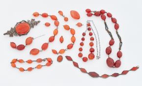 A collection of Carnelian? Jewellery to include an ornate brooch, bead necklaces, bracelet (most