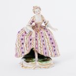 A 19th century porcelain figure of a Lady in the style of Meissen, standing in a period
