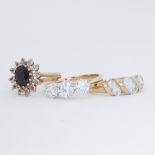 Three 9ct yellow gold rings to include a sapphire cluster ring, three stone crystal set ring & a