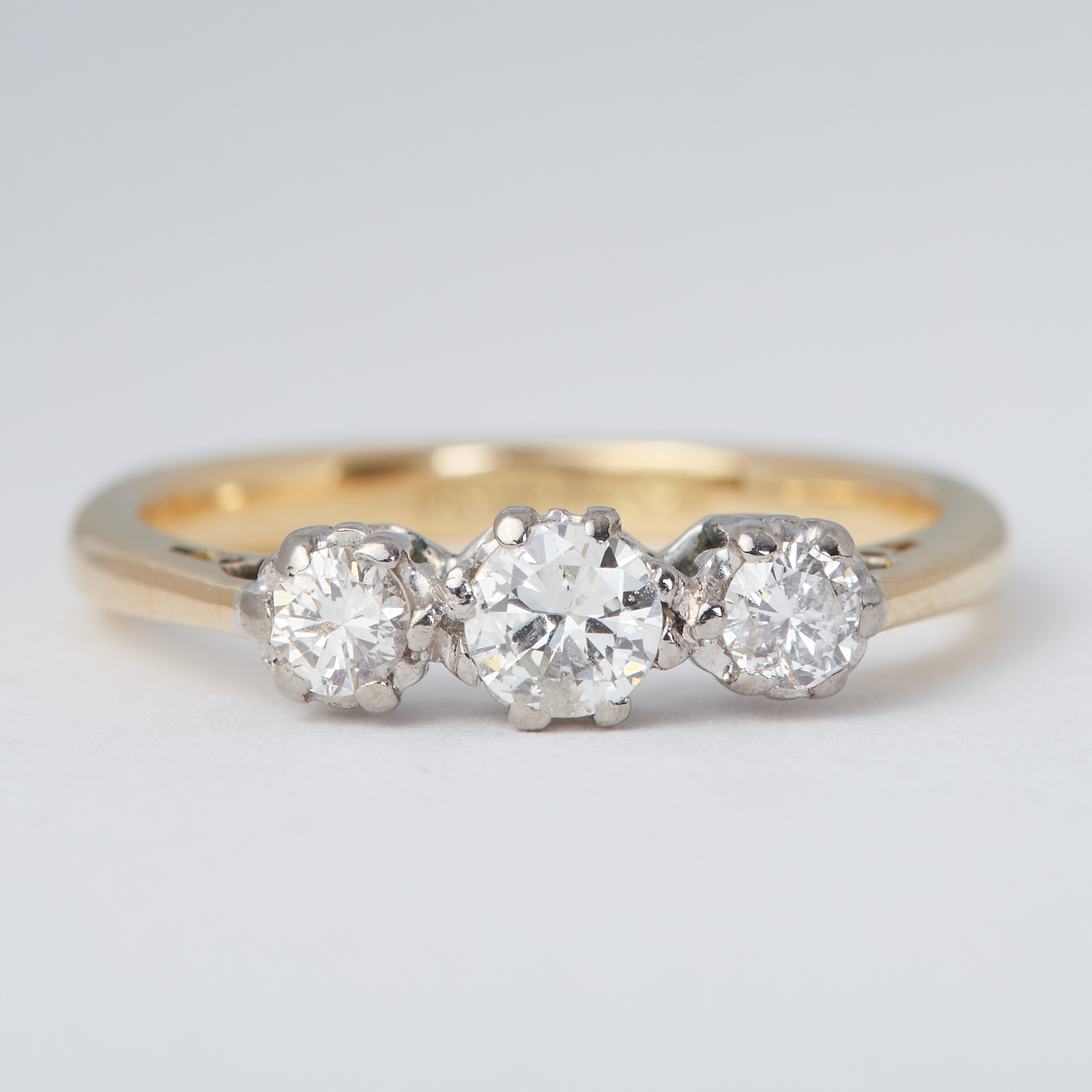 An 18ct yellow gold & platinum three stone ring set with three old round brilliant cut diamonds,