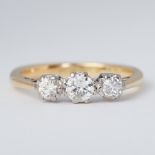 An 18ct yellow gold & platinum three stone ring set with three old round brilliant cut diamonds,