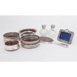 A collection of silverwares to include two cut glass perfume bottles with ornate silver tops, a