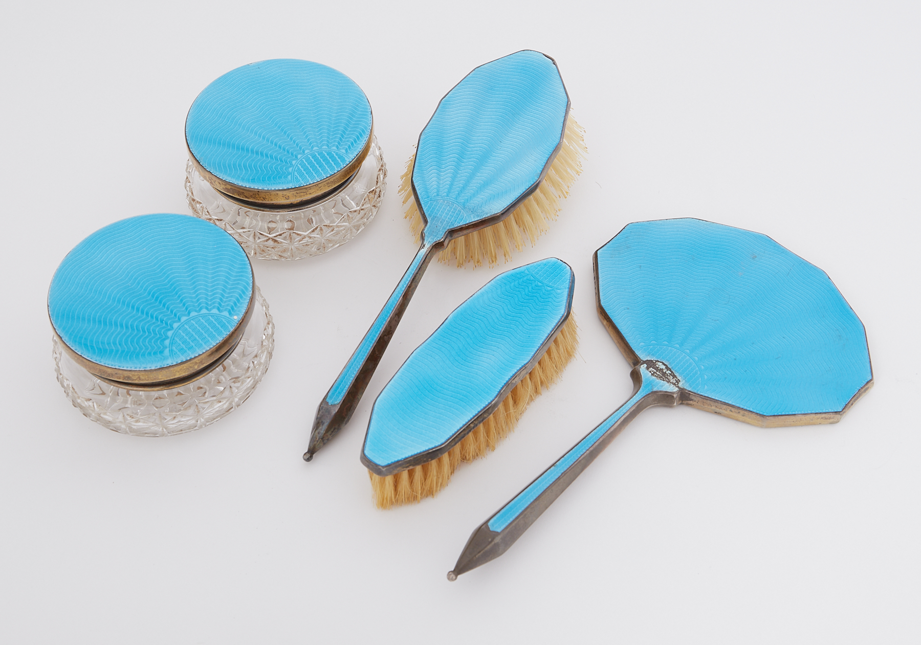A five piece silver & peacock blue enamel dressing table set to include mirror, two brushes & two
