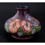 Moorcroft, a squat vase, chipped to base rim, flowers on purple ground, marked 93, height 7cm.