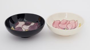 Moorcroft, two small bowls one decorated with purple flower on blue ground and another decorated