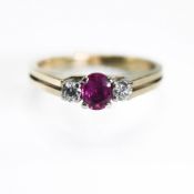 A 9ct yellow & white gold three stone ring set with a central oval cut ruby, approx. 0.20 carats,