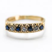 An 18ct yellow gold half eternity style ring set with four round cut dark sapphires, total weight