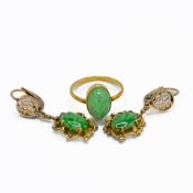 A yellow gold ring set with an oval cabochon cut jade measuring approx. 13mm x 8.5mm x 6mm, Asian