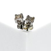 A pair of 18ct white gold stud earrings set with small princess cut diamonds to make up a larger