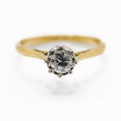 An 18ct yellow & white gold ring set with an older round brilliant cut diamond in an illusion