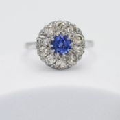 An antique platinum cluster ring set centrally with a round cut Ceylon sapphire, approx. 0.60