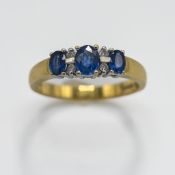 An 18ct yellow & white gold ring set with three oval cut sapphires, total weight approx. 0.65