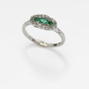 An antique 18ct white gold & platinum ring set with three central emerald cut emeralds surrounded by
