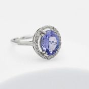 A 14ct white gold ring set with a central 2.63 carat AAA oval cut tanzanite, surrounded by small