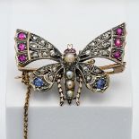 An antique butterfly brooch set with diamonds, ruby's, sapphires and seed pearl.