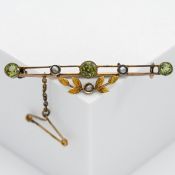 An ornate gold brooch decorated with peridot and seed pearl (not hallmarked).