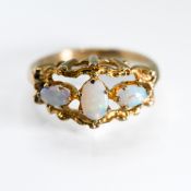 A 9ct yellow gold ornate open design ring set with three oval cabochon cut opals, the centre opal